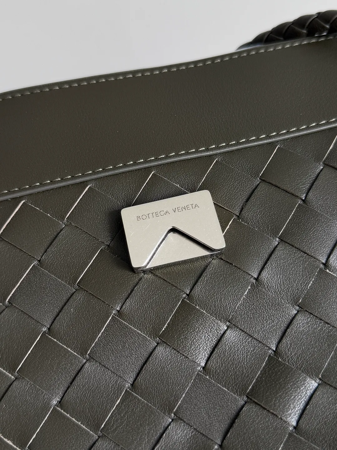 Batch 2460 BOTTEGA VENETA Bottega Veneta's 2025 new product for men ANDIAMO Bottega Veneta's main recommendation is undoubtedly the Andiamo small size. The first new favorite of the 2025 new product is a men's figure buckle bag. It can be seen that the designer has used many small ideas. The detachable crossbody strap is very convenient. It is convenient for elite office workers to reduce the burden on their hands when carrying work logs and office supplies. The interior is divided into two large compartments and a small zippered compartment. Unlike the women's model, the compartments here are not removable. The fixed large single layer also makes it easier to pack lightly when going out to work, and avoids the accumulation of too many small items. Style number: 815781 Size: 29*20*13cm